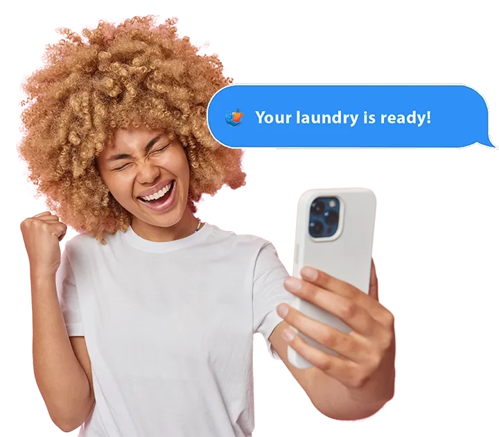 Woman celebrating a Your laundry is ready text on her phone